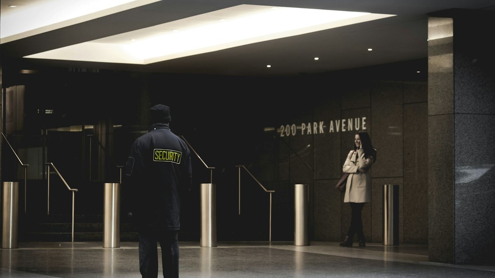 A New Edge Security guard on duty at a modern building entrance